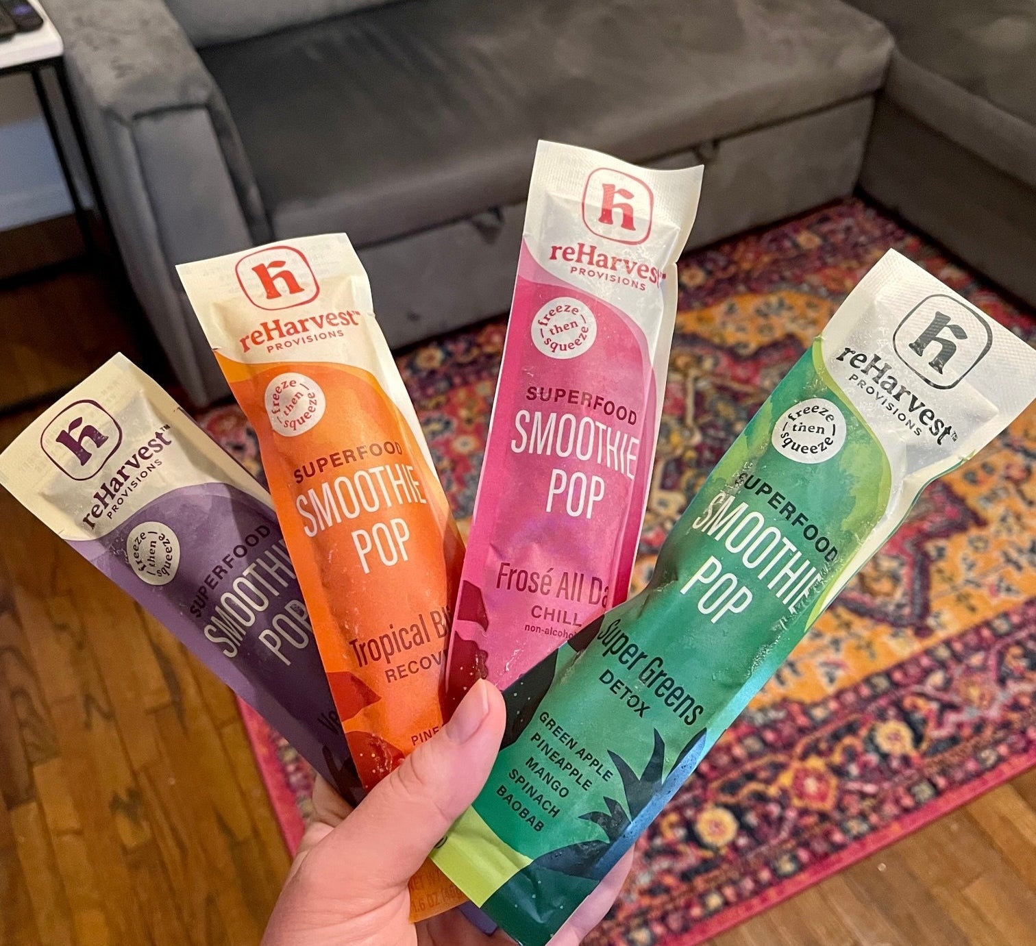 hand holding four different kinds of smoothie pops