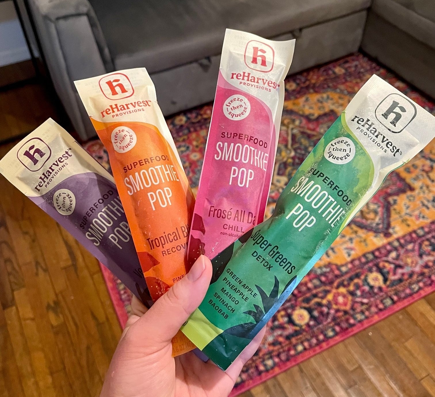 hand holding four different kinds of smoothie pops