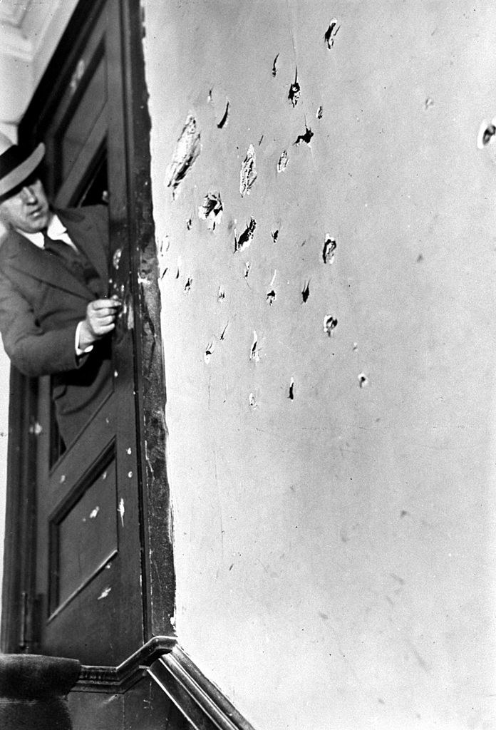 A detective checks out bullet holes