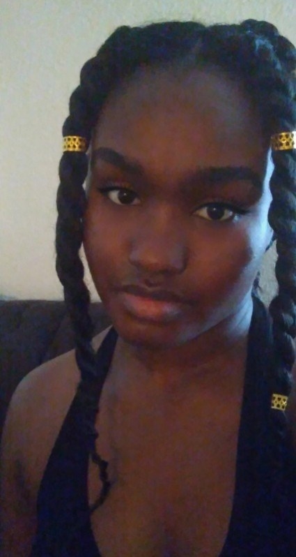 A Community User wears their hair in long jumbo twists that have gold clips as accessories