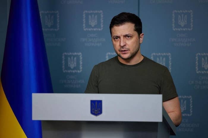 A man in a green t-shirt stands behind a podium. 