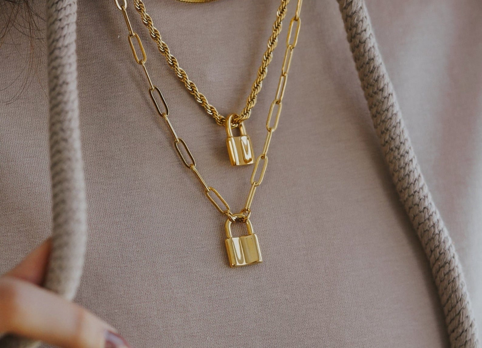 model wearing both the rope chain padlock and paperclip chain padlock necklaces