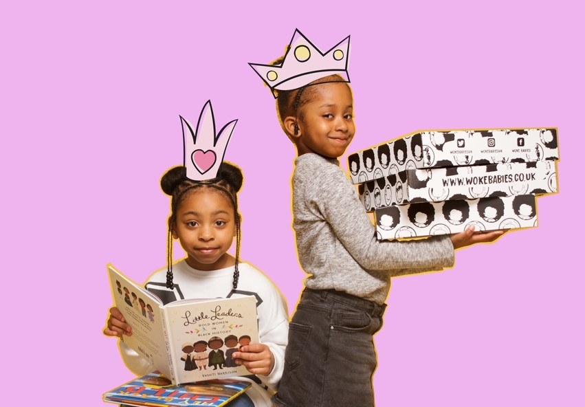 Child models pose with the Woke Babies subscription box and its contents.