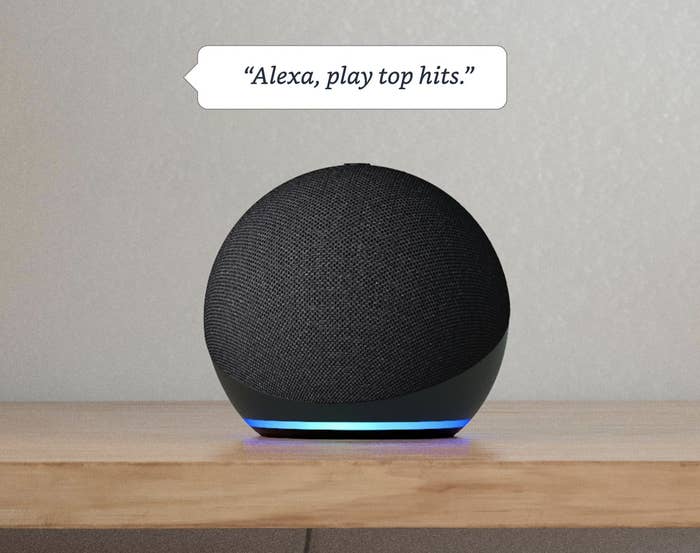 the echo dot with text above it that reads &quot;alexa, play top hits&quot;