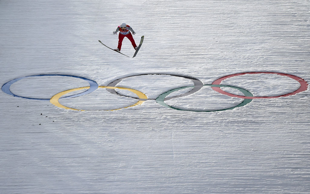 A skier flies over the Olympic rings