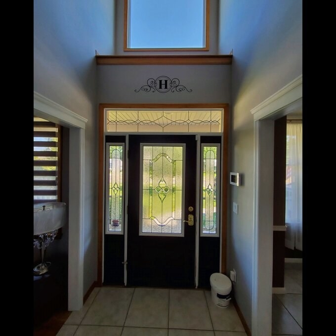 A reviewer&#x27;s image of a monogram design wall decal above a front door