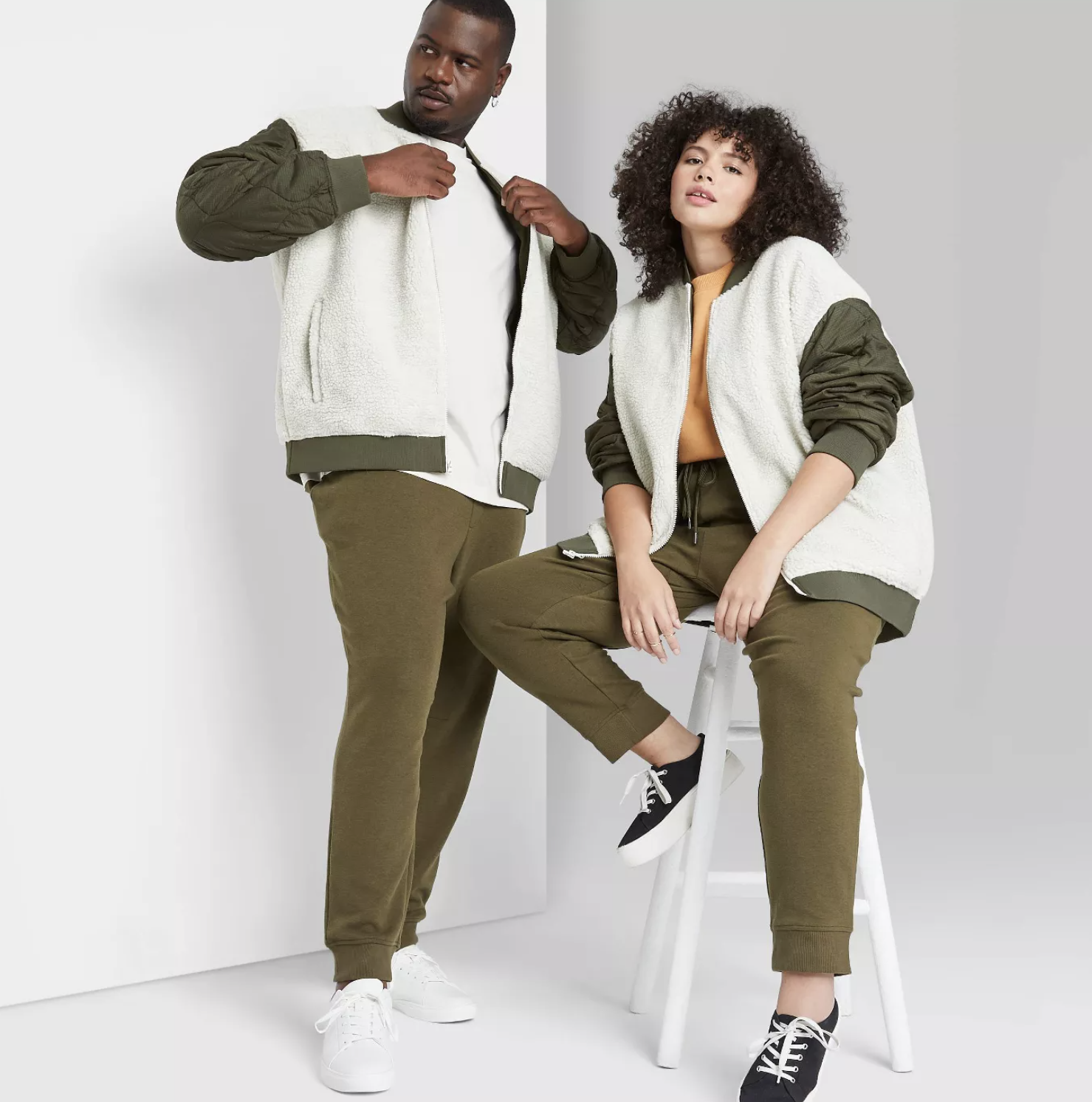 two models wearing the bomber jacket in white with green sleeves and green trimming