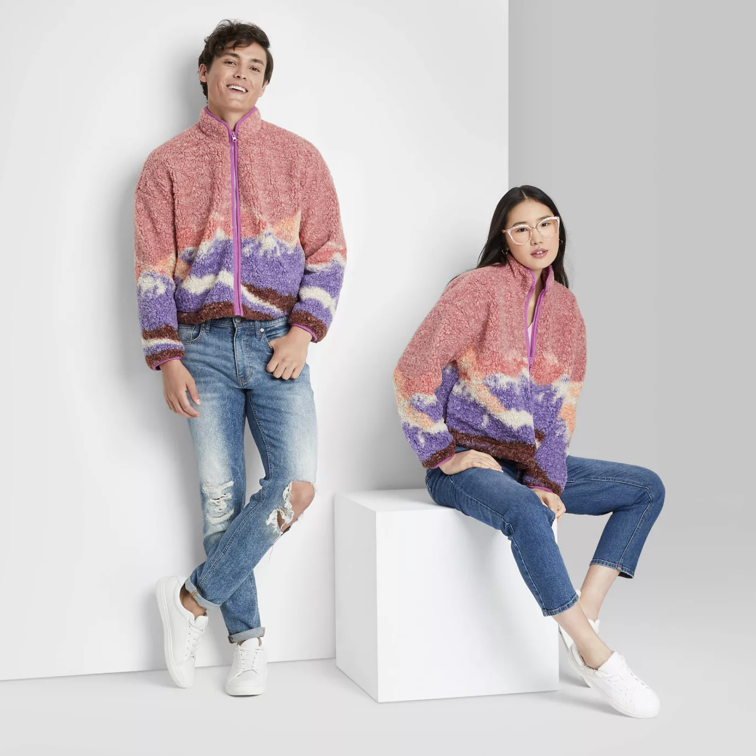 two models wearing the sherpa jackets in pink with purple and orange patterning