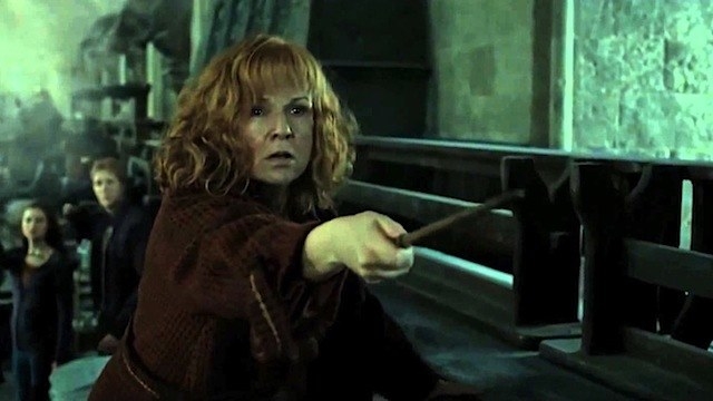 molly weasley, who has bangs and shoulder-length curly hair, holds a wand out in front of her