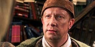 Arthur Weasley wears a leather hat and has his brows furrowed, mouth slightly open