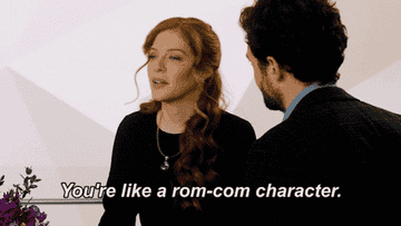 A red-headed woman saying &quot;You&#x27;re like a rom-com character&quot; to a dark-haired man