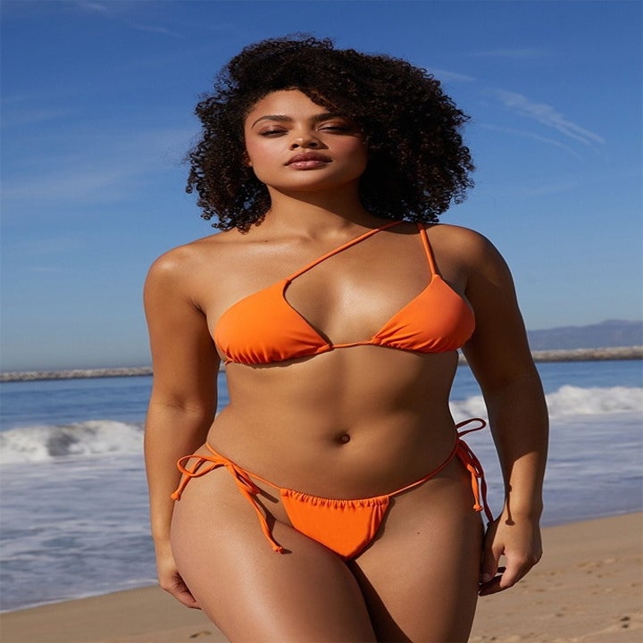 model wearing orange one-shoulder bikini