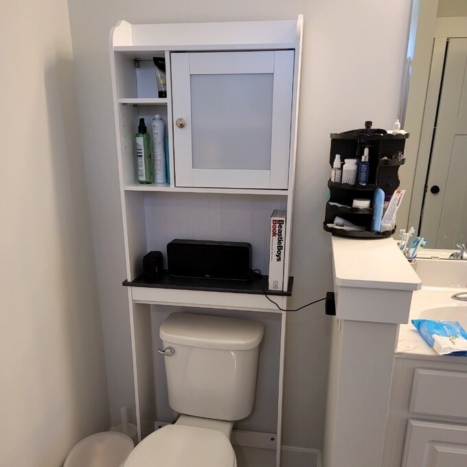 A reviewer&#x27;s image of a over-the-toilet storage unit