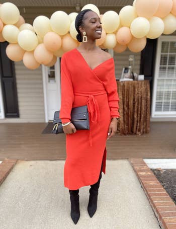 A customer review photo of them wearing the dress in red with black boots