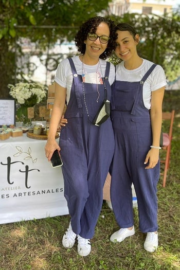 a reviewer photo of two people wearing the overalls in navy with white T-shirt underneath