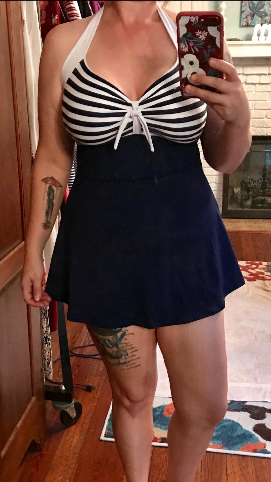 Reviewer photograph  of them wearing the navy and achromatic  striped aquatics  dress