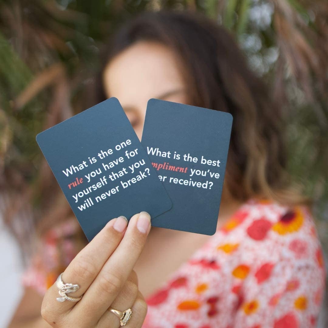 A person holding two cards up to the camera
