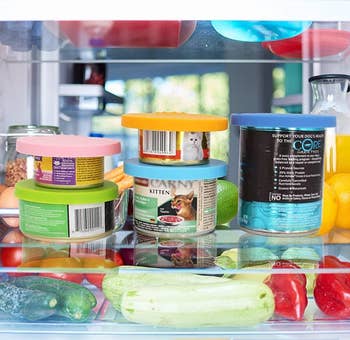 various cans of food in the fridge with silicone lids on them