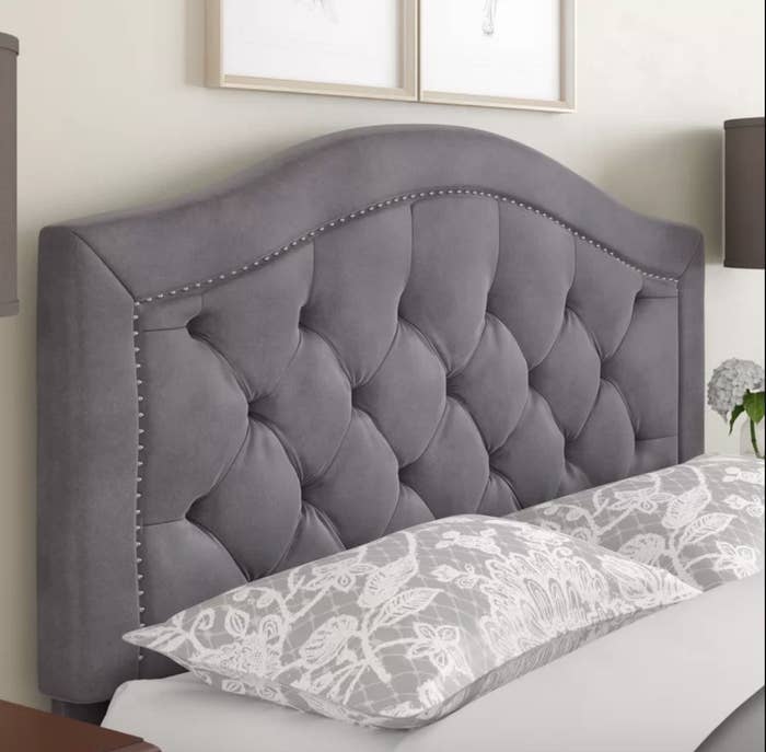 Close up of gray upholstered headboard behind bed