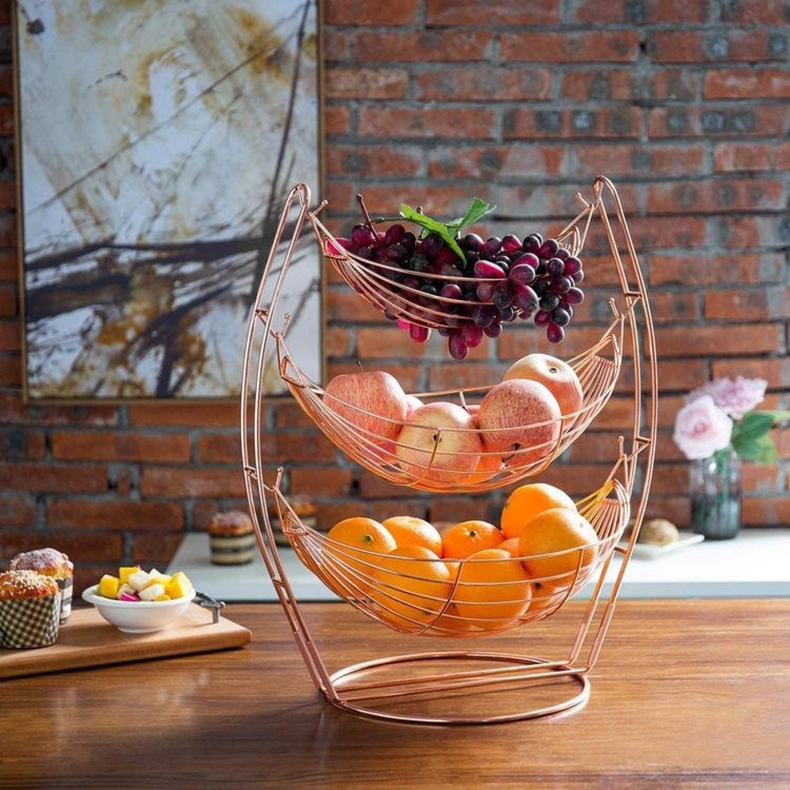 a three-tier rose gold hammock-style fruit basket