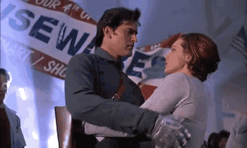 GIF of Ash from Evil Dead kissing a woman and saying &quot;Hail to the king, baby&quot;