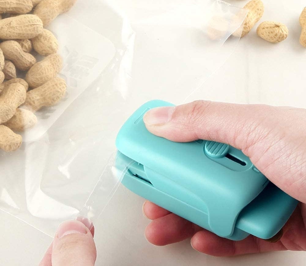 a person using the bag sealer to close up a bag of peanuts