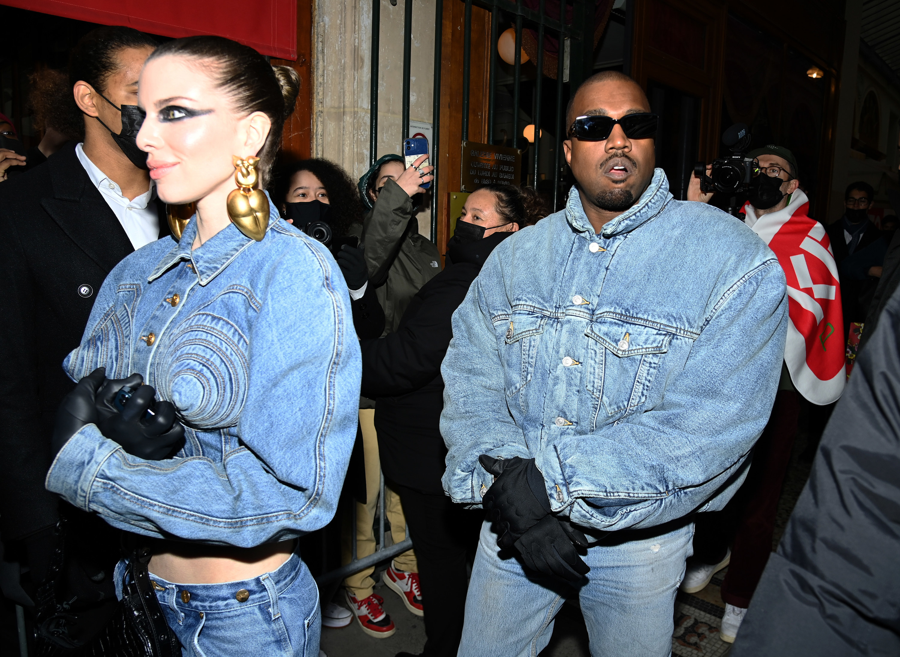 Kanye and Julia walk through a crowd while wearing all denim