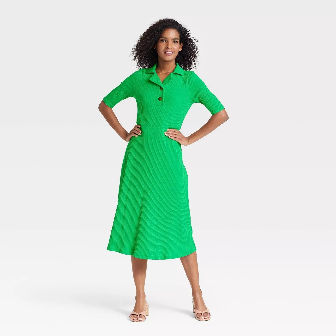 Model wearing green dress with collard neck, goes past the knee