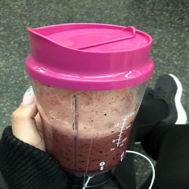 reviewer holding the travel cup