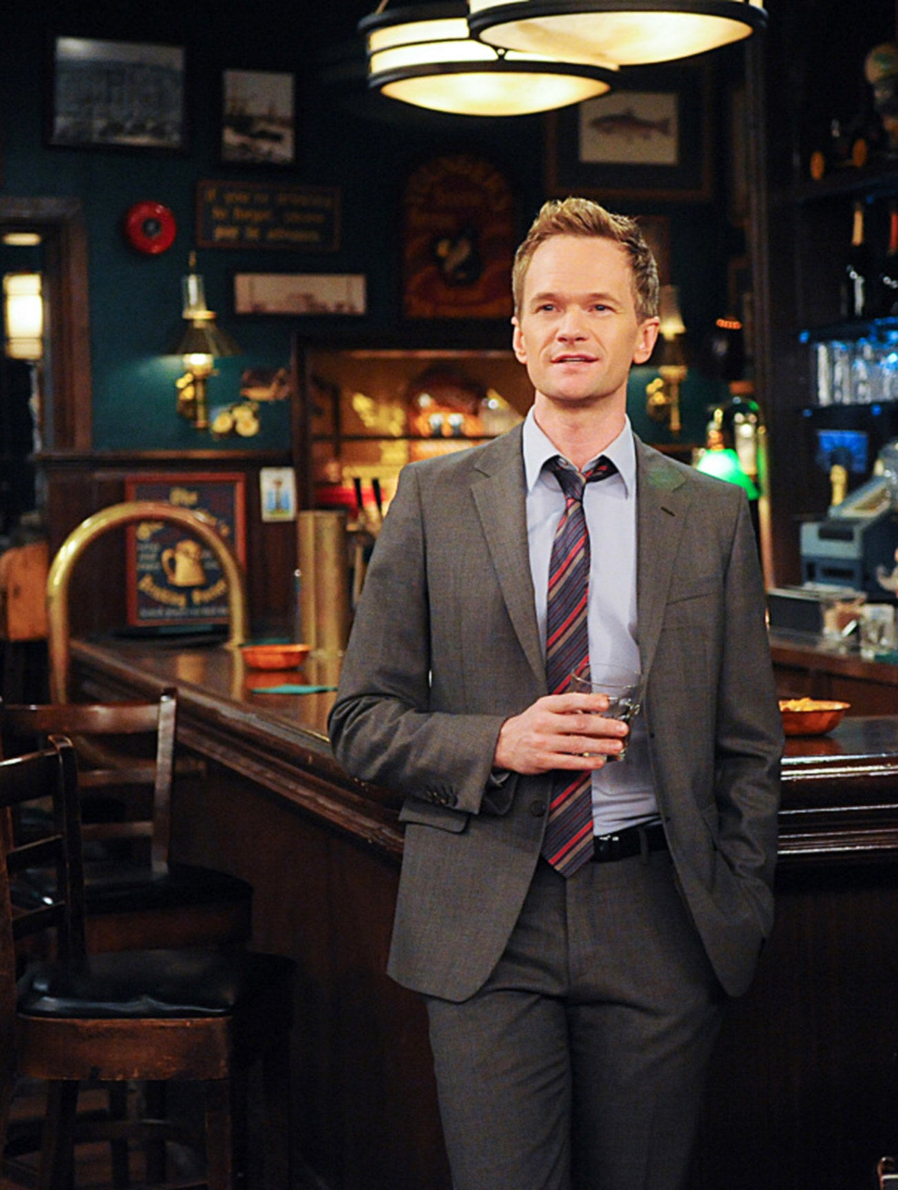 Barney stands in a bar
