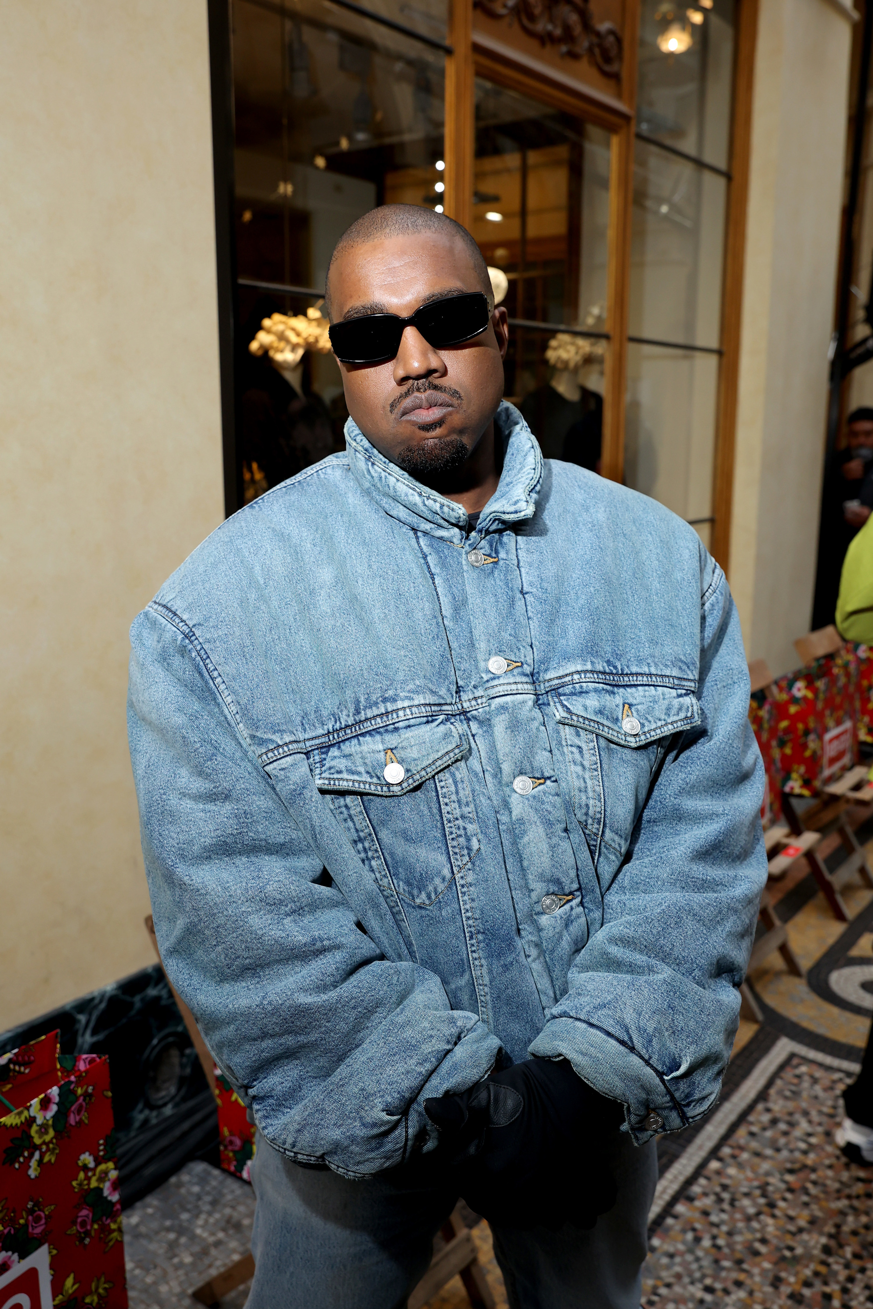 Kanye posing for a photo wearing an all-denim outfit and sunglasses