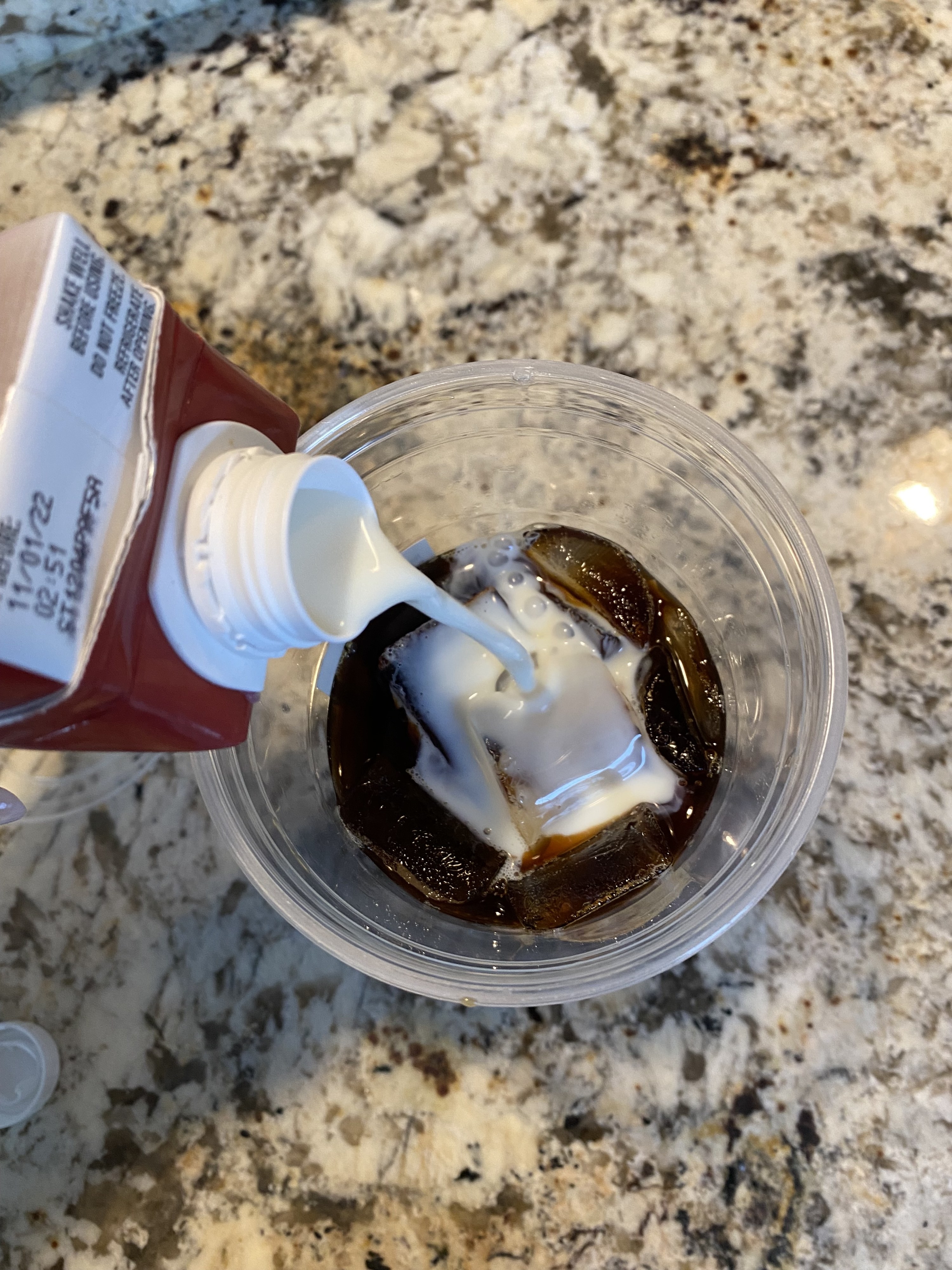 The Quest protein shake being poured into the iced coffee