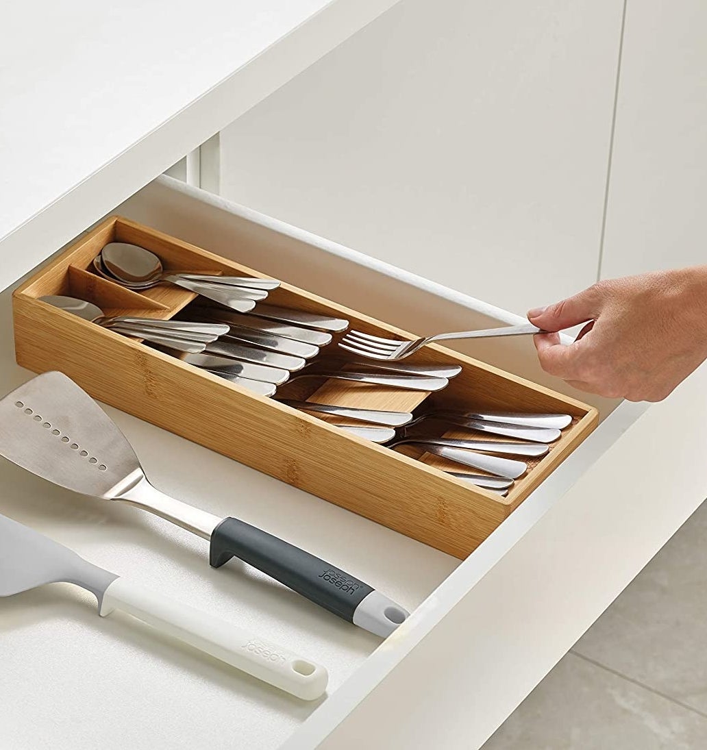 A person putting a fork into the filled organizer