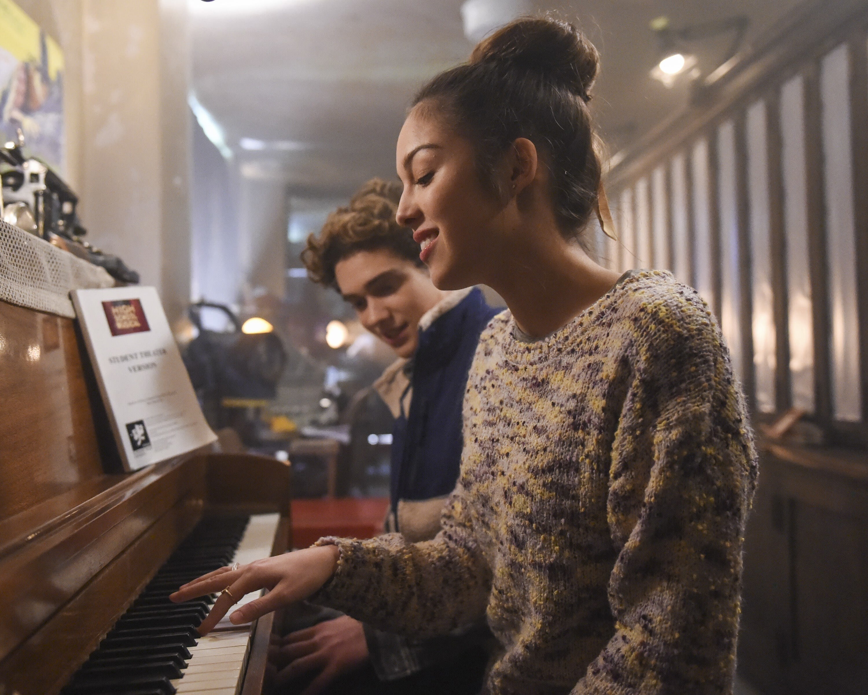 Teen girl in sweater playing the piano