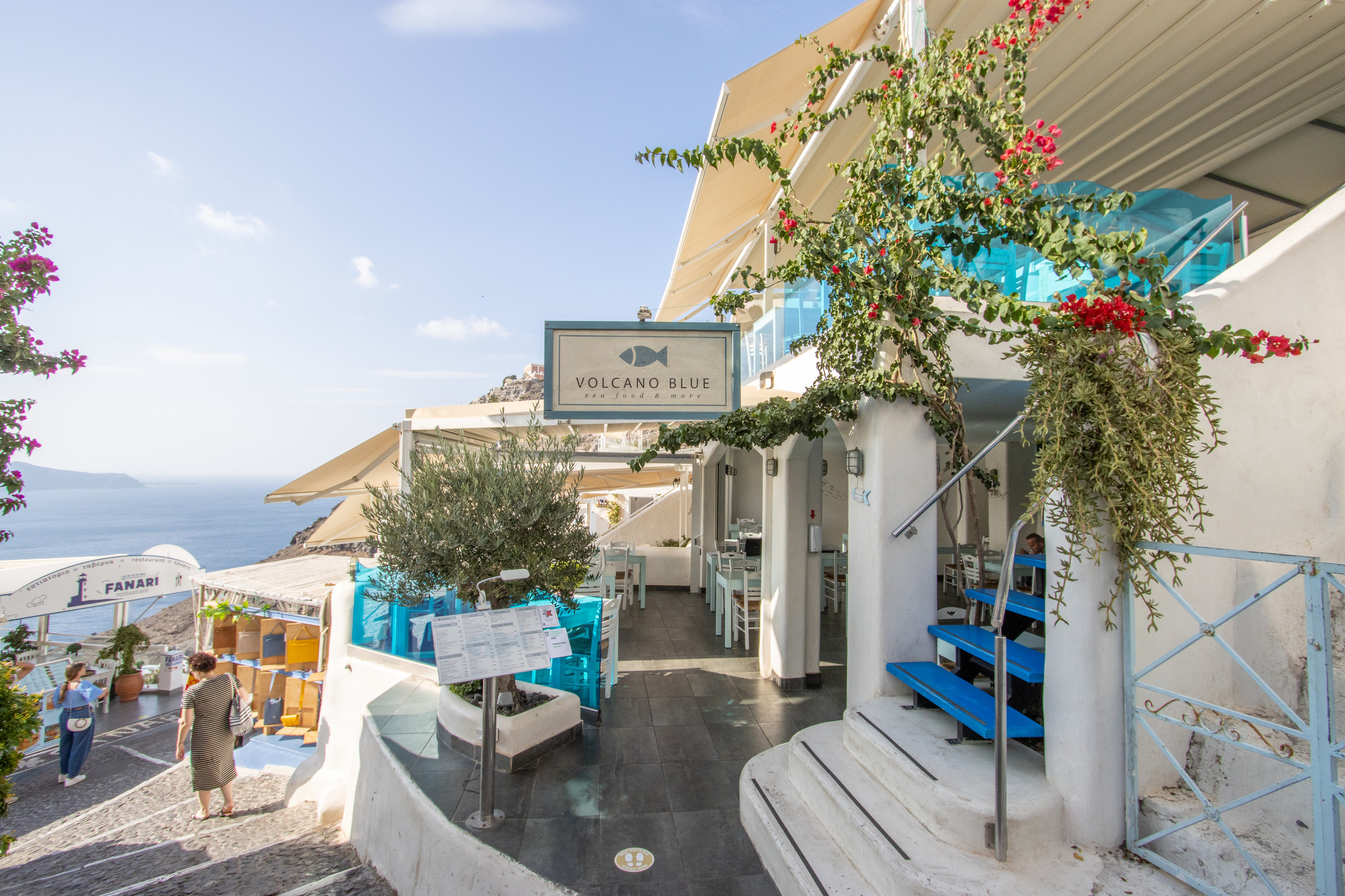 Volcano Blue Seafood Restaurant in Firá on Santorini in South Aegean Islands, Greece, with tourists in the background