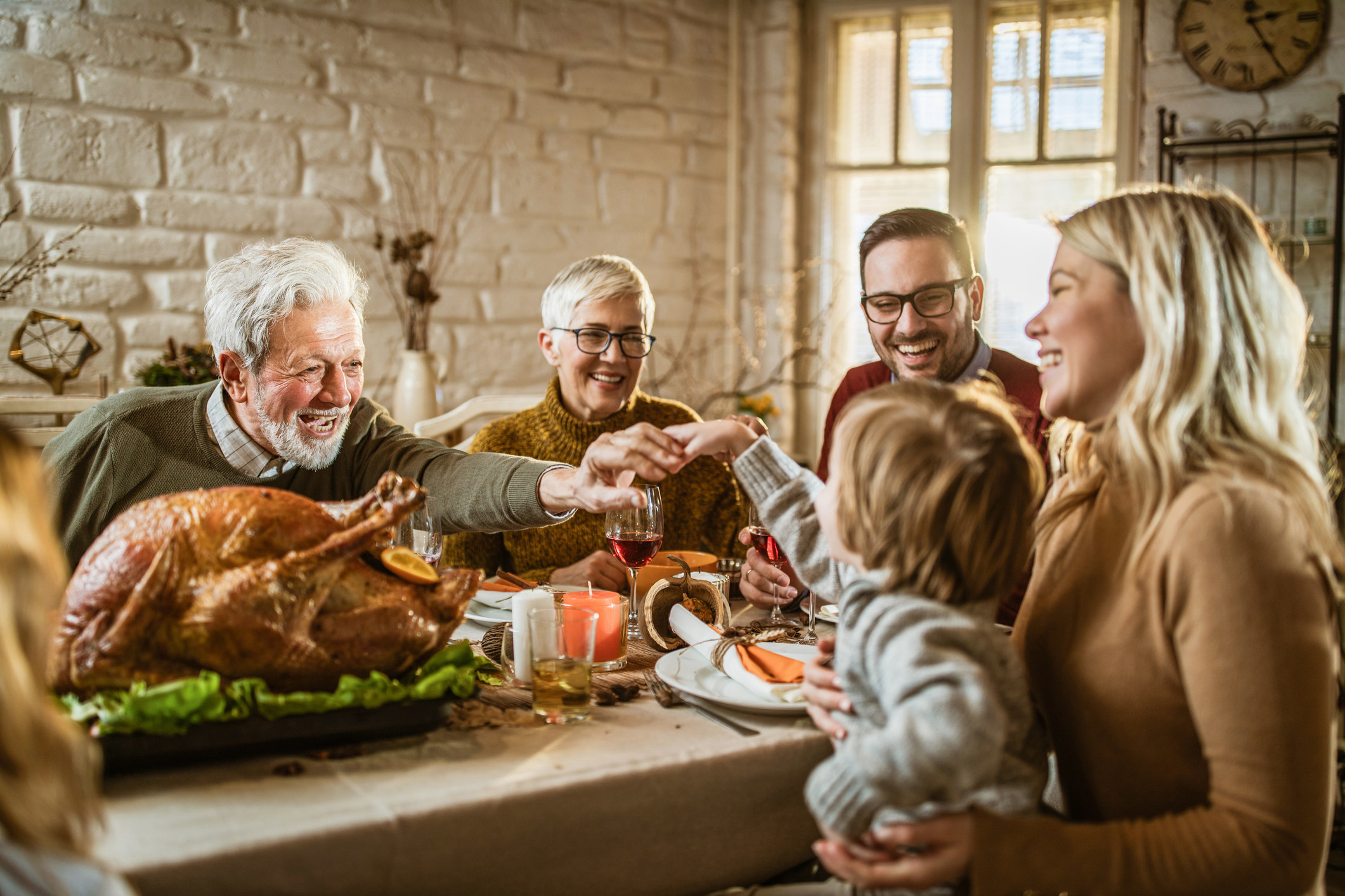 Family members smile and chat over Thanksgiving dinner