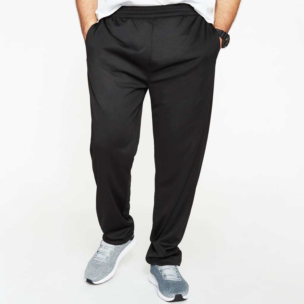 A person&#x27;s legs wearing the tapered track pants with a pair of running shoes