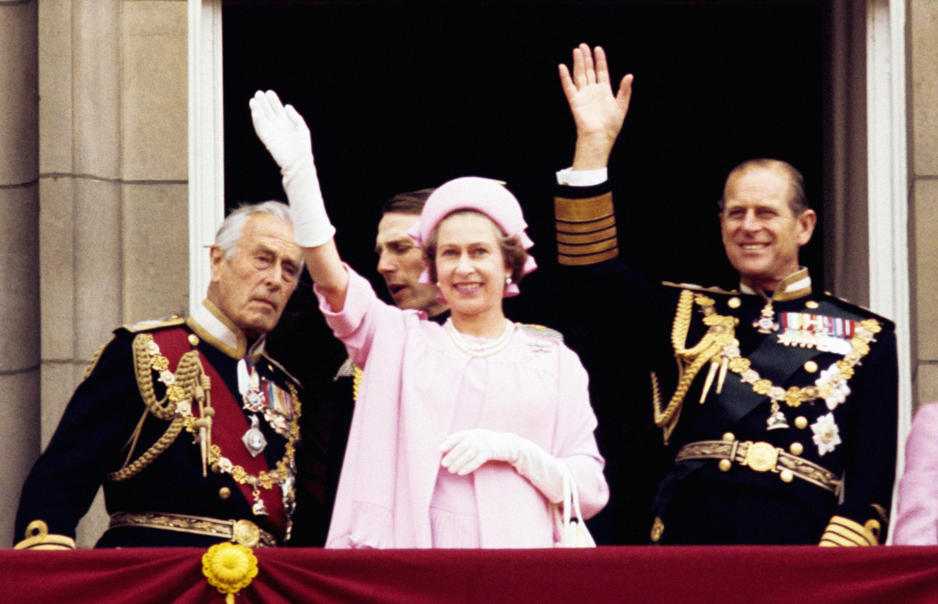 Queen Elizabeth II and philip waving from a balcony 