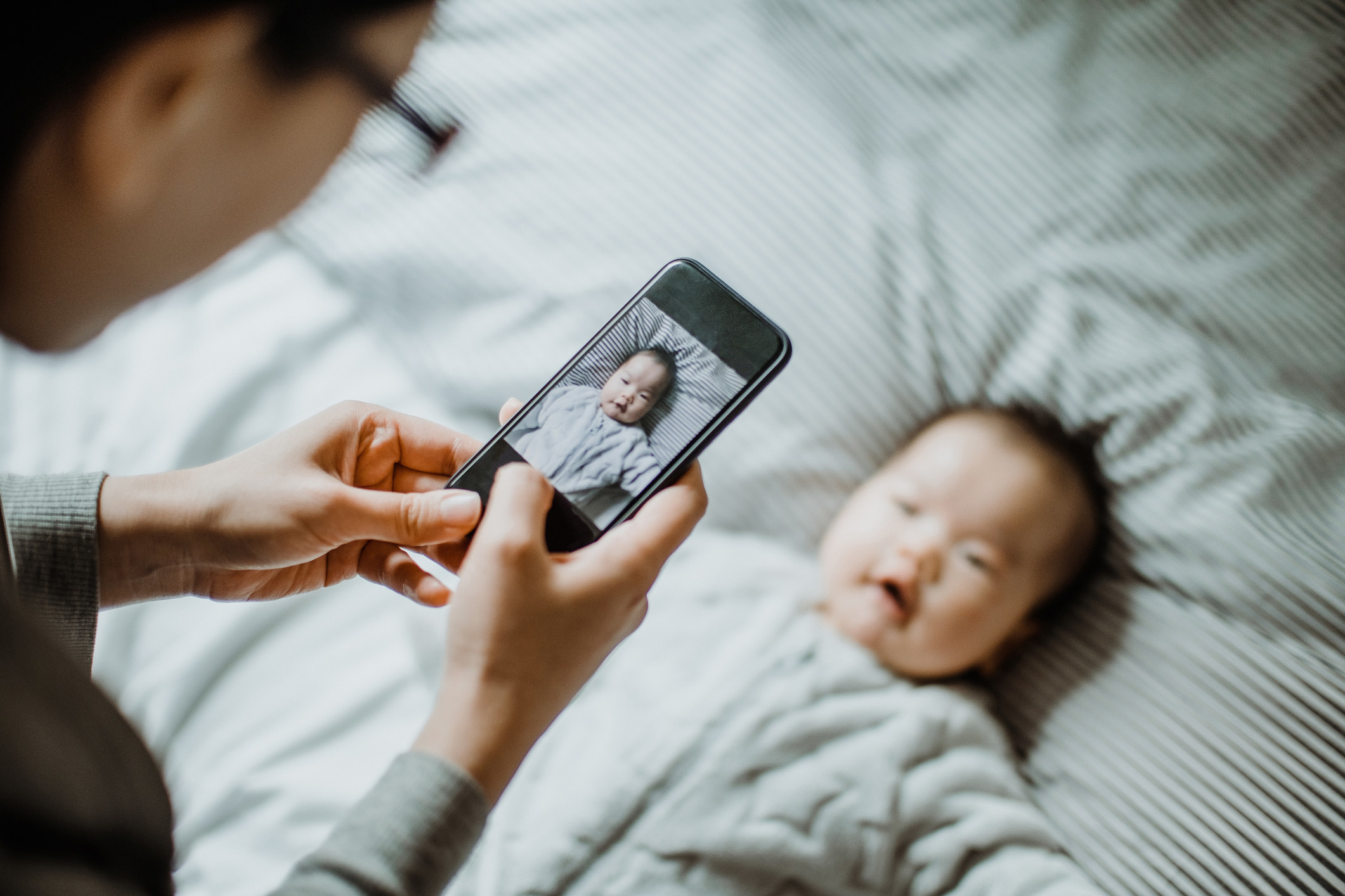 A parent takes a photo of their baby