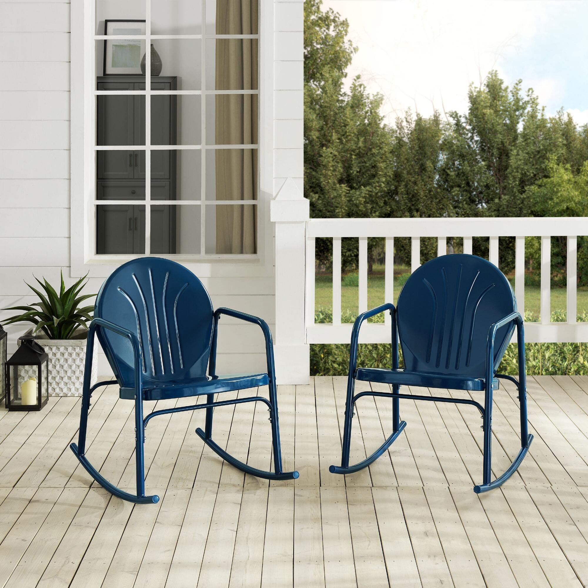 two navy blue metal rocking chairs on a porch