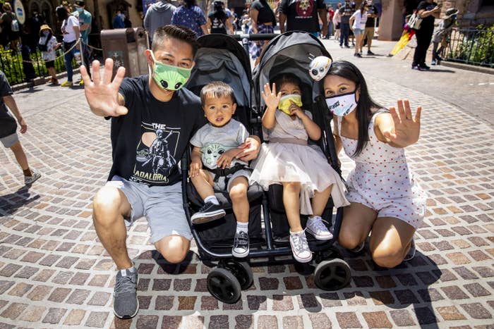 A family at Disney with their two kids using the force hand signal