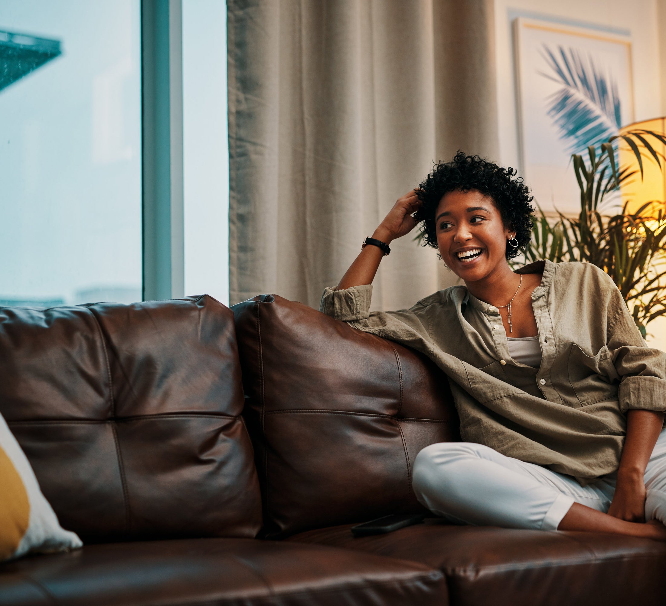 Woman sitting on a leather couch in a cozy living room