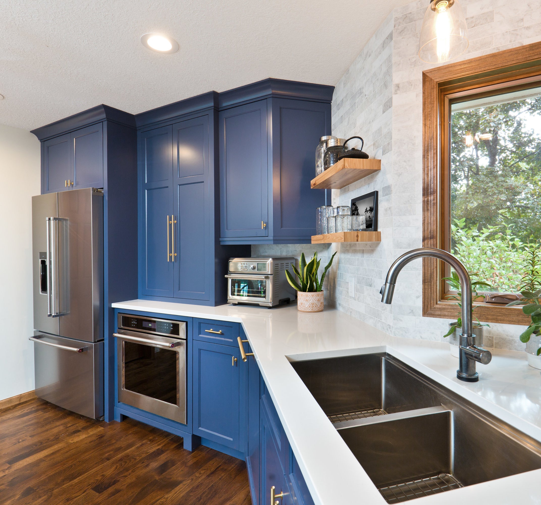 Kitchen with dark blue cabinets and wooden window accents