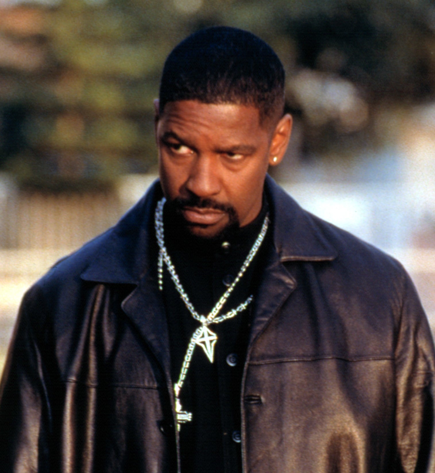 Denzel Washington as Alonzo Harris, wearing all black, including a leather jacket