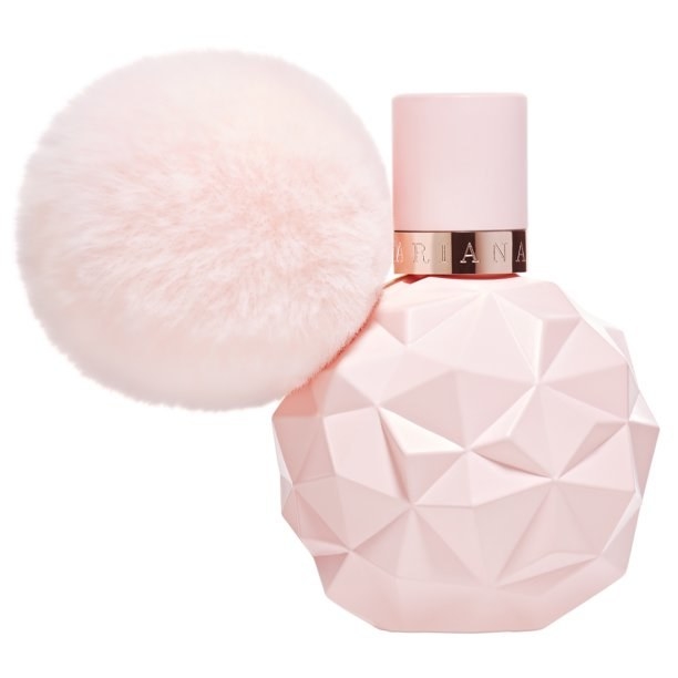 A pink perfume bottle with a pink poof