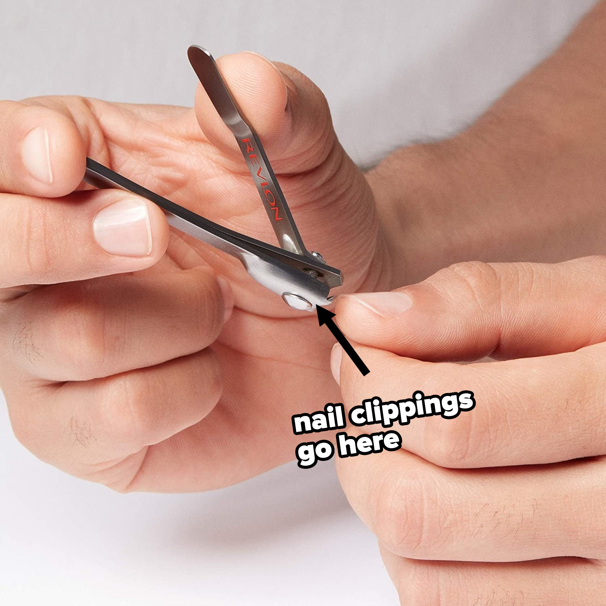 someone using the clippers, with an arrow and text indicating where the nail clippings will go