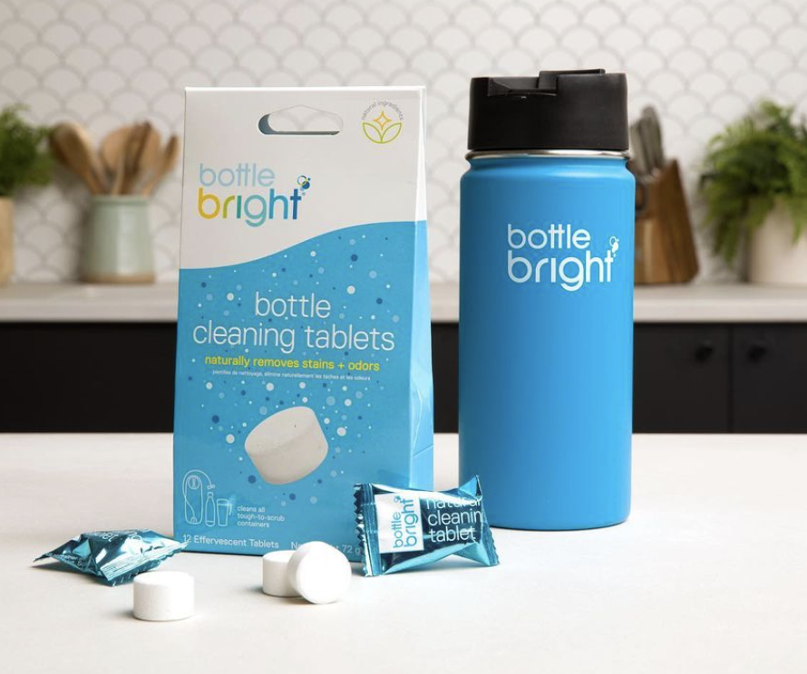 The bottle cleaning tablets, some unwrapped, and the box they come in next to a water bottle with the bottle bright logo