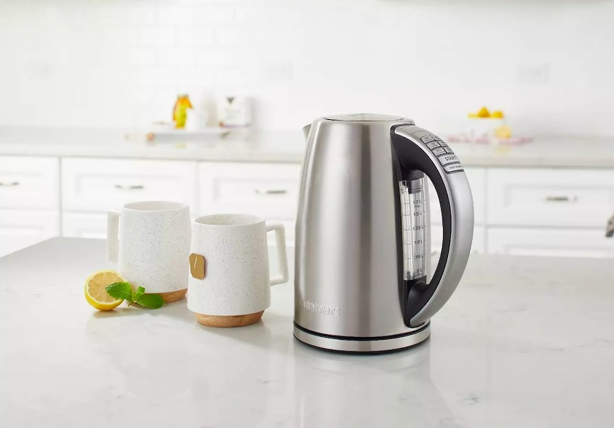 Kettle sitting next to two mugs on a kitchen counter