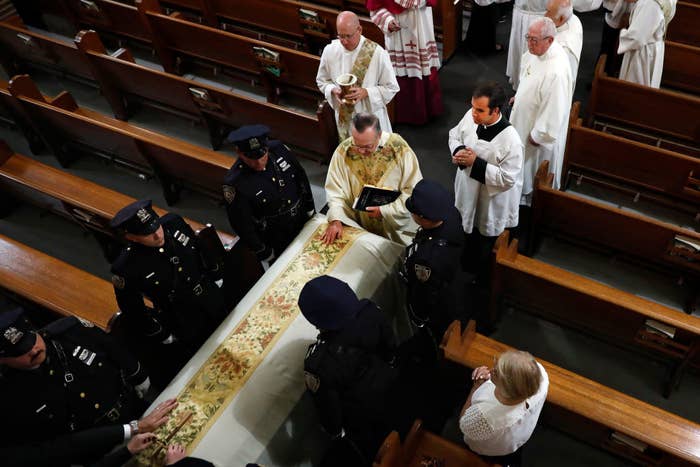 Police officers carrying a coffin inside a church