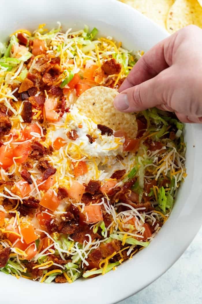 Dipping a chip into BLT dip.